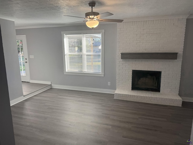 unfurnished living room with ceiling fan, a wealth of natural light, a fireplace, and dark hardwood / wood-style floors