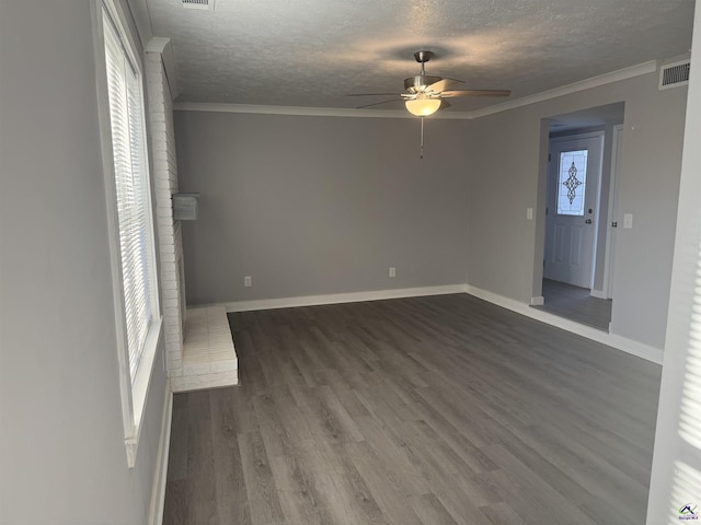 unfurnished living room with dark wood-type flooring, a textured ceiling, crown molding, and a wealth of natural light