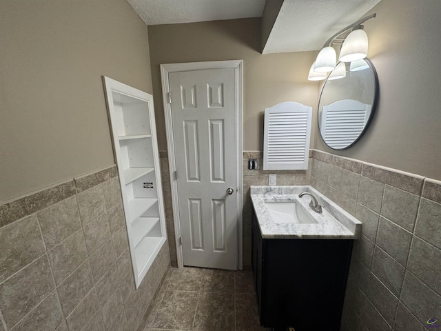 bathroom with vanity and tile walls