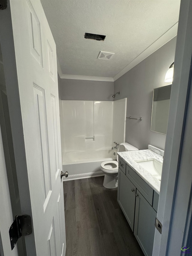 full bathroom featuring toilet, shower / tub combination, wood-type flooring, ornamental molding, and vanity