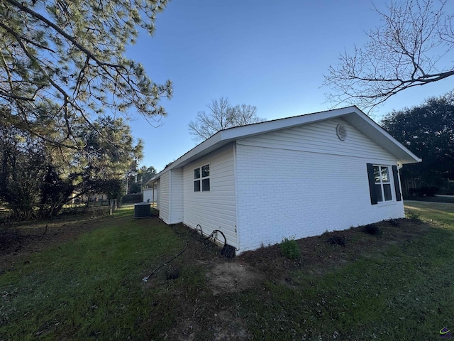 view of home's exterior with central air condition unit and a yard