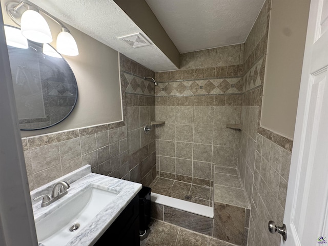 bathroom featuring vanity, tile walls, and tiled shower