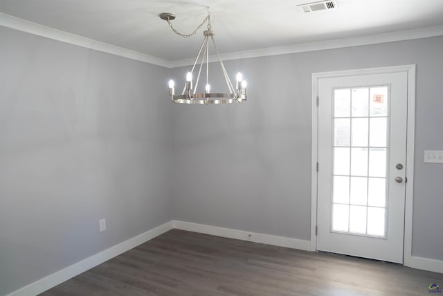 unfurnished dining area with dark wood-type flooring, ornamental molding, and a chandelier