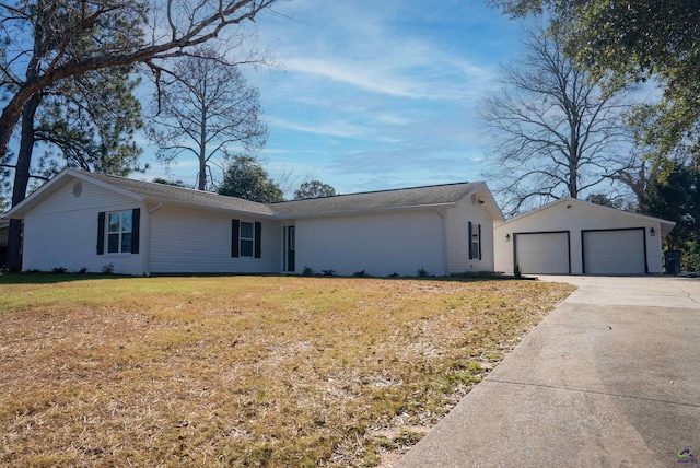 single story home with a front yard, a garage, and an outbuilding