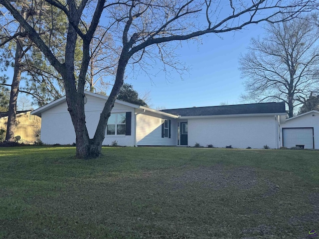 ranch-style house with a garage and a front lawn