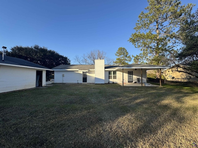 back of property featuring a lawn and a patio area