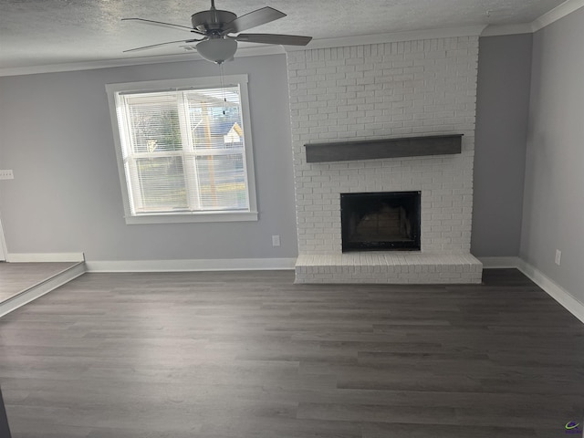 unfurnished living room with ceiling fan, a brick fireplace, dark hardwood / wood-style flooring, and ornamental molding