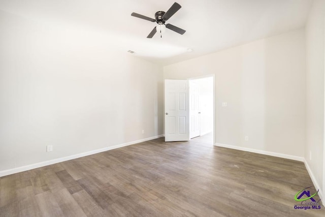 empty room featuring ceiling fan and dark hardwood / wood-style flooring