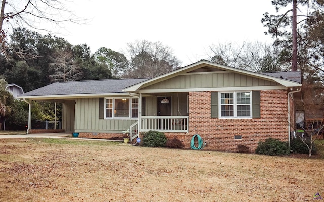 ranch-style home featuring covered porch, a front lawn, and a carport