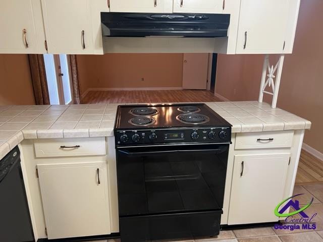 kitchen featuring black appliances, tile counters, and white cabinetry