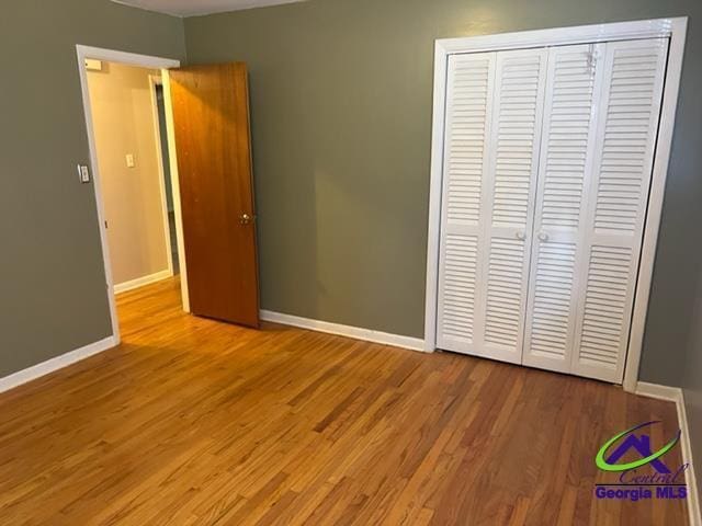 unfurnished bedroom with light wood-type flooring and a closet