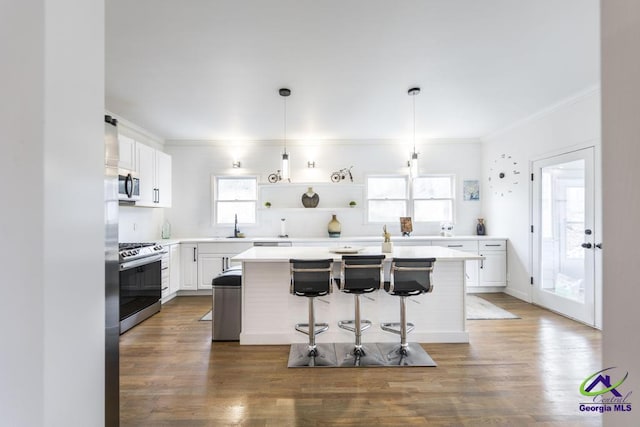 kitchen with a breakfast bar, a center island, white cabinetry, and stainless steel appliances