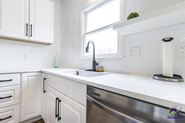 kitchen with a wealth of natural light, white cabinetry, dishwasher, and sink