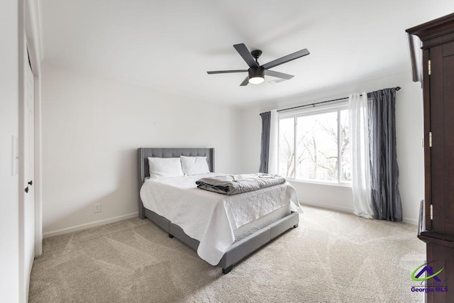 bedroom with ceiling fan, light carpet, and a closet