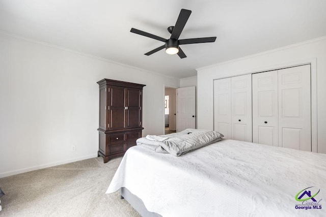 carpeted bedroom featuring a closet, ceiling fan, and ornamental molding