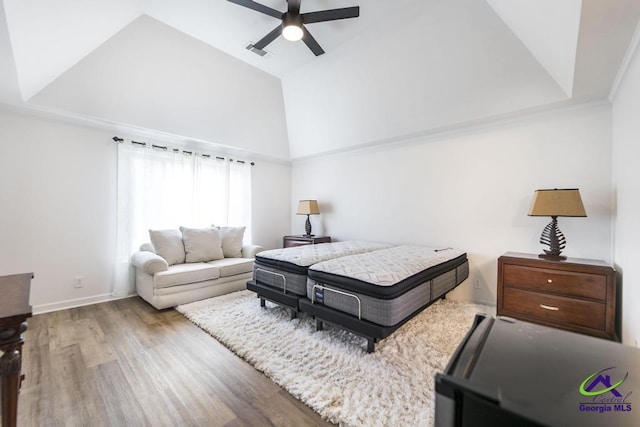 bedroom featuring hardwood / wood-style floors, a tray ceiling, ceiling fan, and crown molding