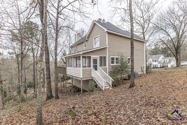 view of front of home featuring central AC and a sunroom