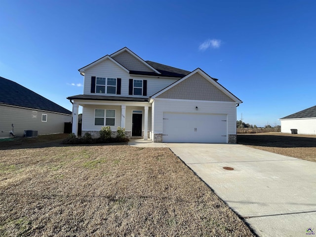 view of front of home with a front lawn, covered porch, central AC unit, and a garage