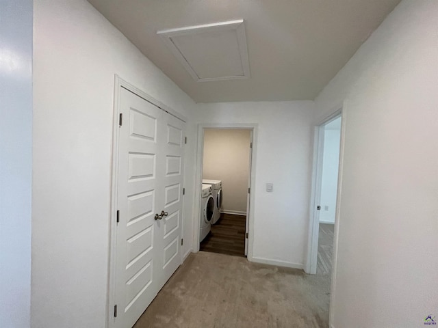 corridor featuring light carpet and washing machine and clothes dryer