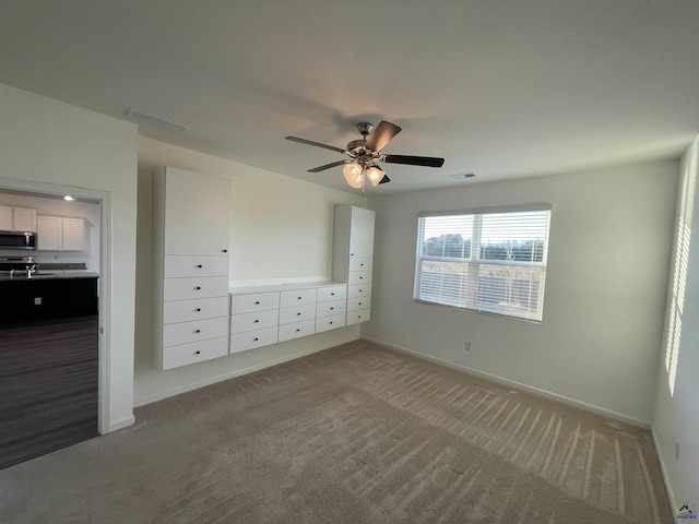 unfurnished bedroom with ceiling fan, sink, and light carpet