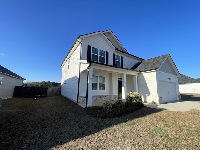 view of front of home featuring a porch, a garage, and a front lawn