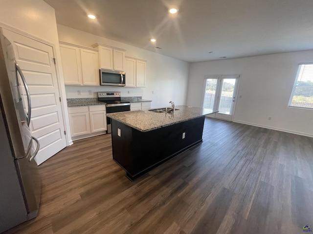 kitchen with white cabinetry, sink, dark hardwood / wood-style floors, a center island with sink, and appliances with stainless steel finishes