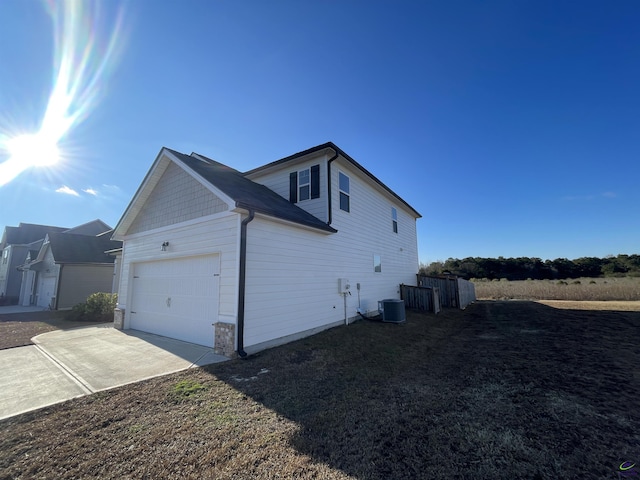 view of side of property with a garage and cooling unit