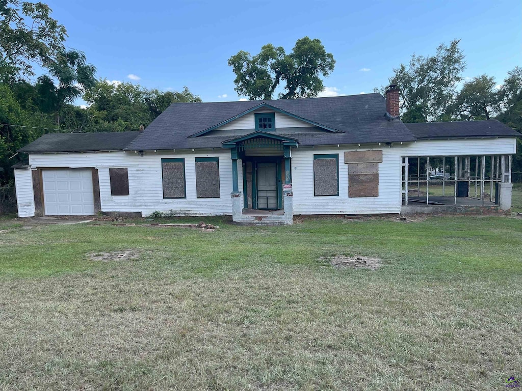 view of front of property featuring a garage and a front lawn