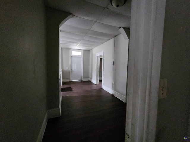 hall featuring a paneled ceiling and dark hardwood / wood-style floors