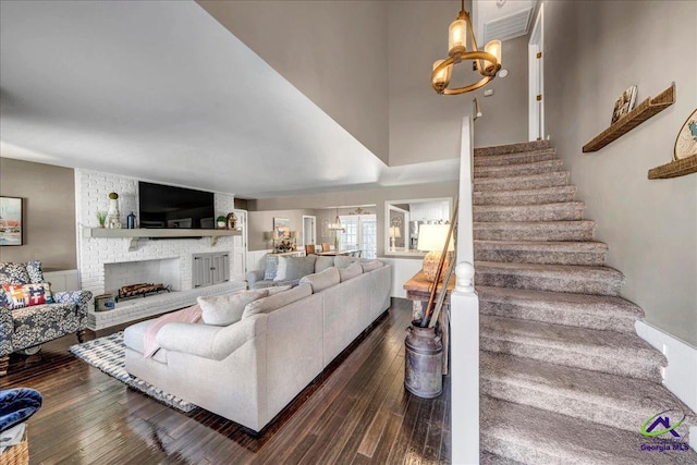 living room with a fireplace, dark hardwood / wood-style flooring, and a notable chandelier