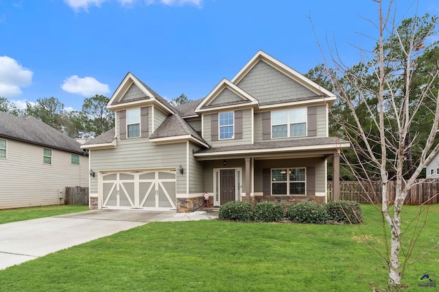 craftsman inspired home with a garage and a front lawn