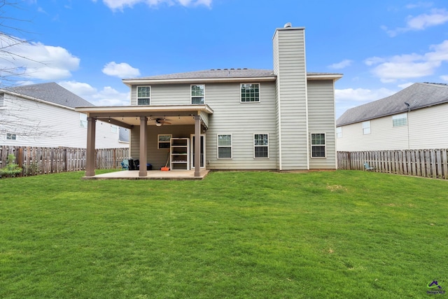 back of property with a lawn, ceiling fan, and a patio