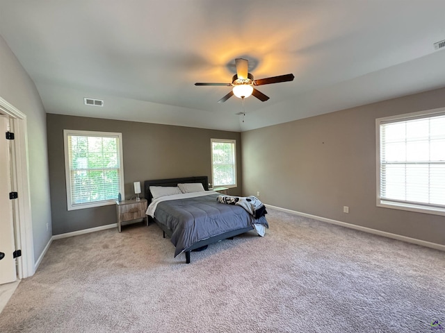 carpeted bedroom featuring ceiling fan, baseboards, and visible vents