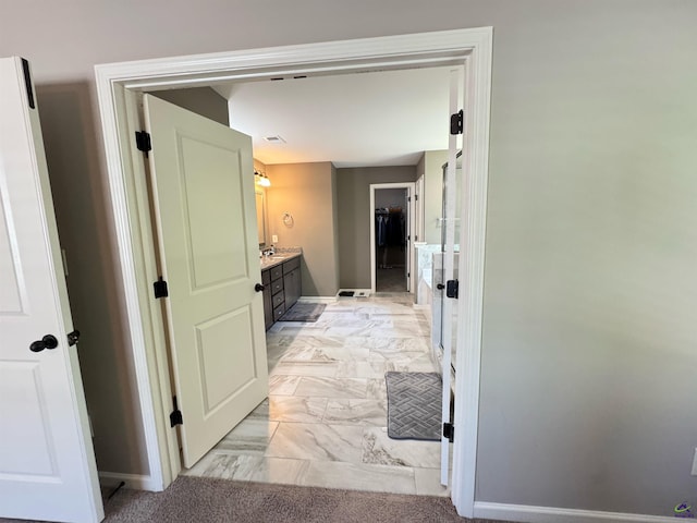 hall with marble finish floor and baseboards