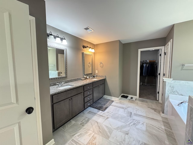 bathroom featuring baseboards, visible vents, a sink, and double vanity