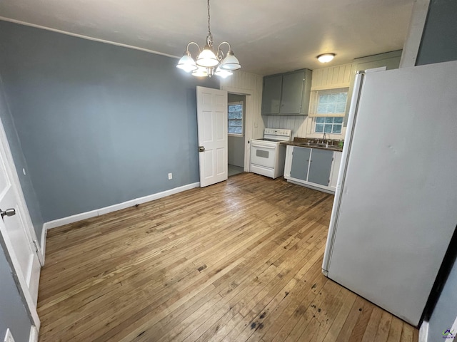 kitchen with white appliances, sink, wood-type flooring, an inviting chandelier, and gray cabinets