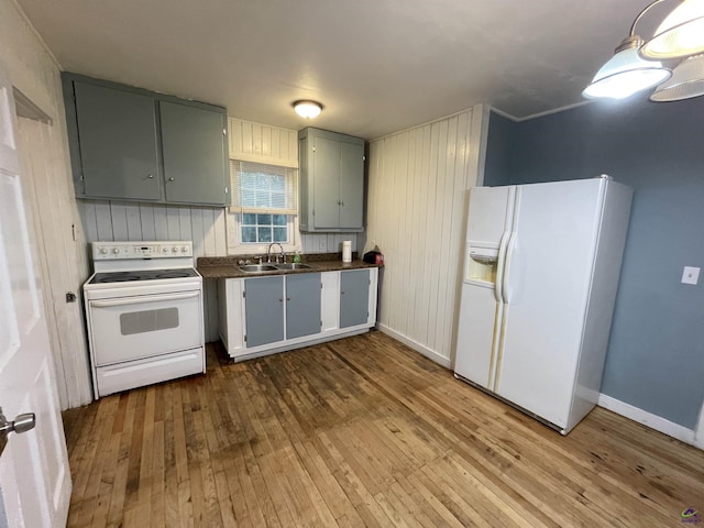 kitchen featuring light wood-type flooring, white appliances, and sink