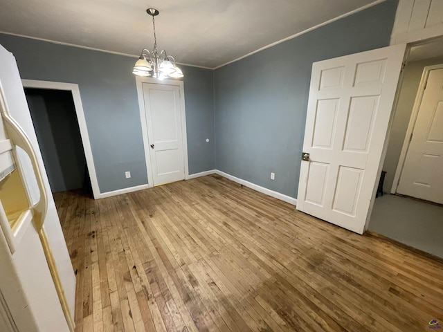 interior space with a chandelier, hardwood / wood-style floors, and ornamental molding