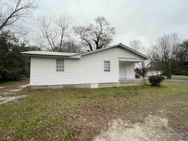 view of property exterior with a lawn and a porch