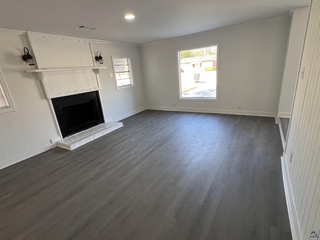 unfurnished living room with crown molding, dark wood-type flooring, and a brick fireplace