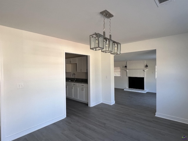 unfurnished dining area featuring sink and dark wood-type flooring