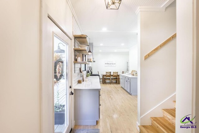 bar featuring gray cabinets, crown molding, and light wood-type flooring