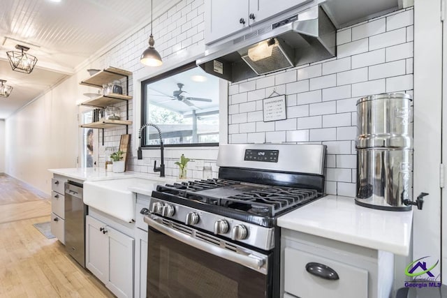 kitchen with sink, hanging light fixtures, decorative backsplash, white cabinetry, and stainless steel appliances