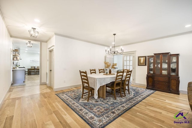 dining area featuring hardwood / wood-style floors, an inviting chandelier, and ornamental molding