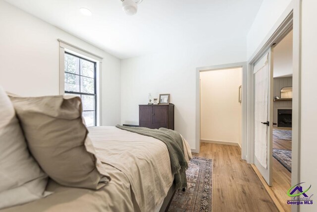 bedroom with a fireplace and light hardwood / wood-style floors