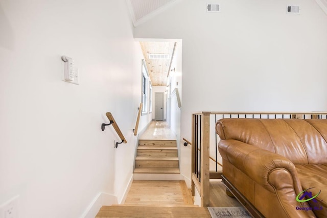 stairs featuring wood-type flooring and ornamental molding