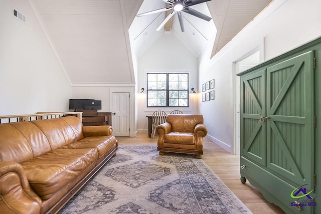 living room with ceiling fan, light hardwood / wood-style floors, and high vaulted ceiling