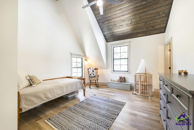 bedroom featuring light hardwood / wood-style floors, high vaulted ceiling, and ceiling fan