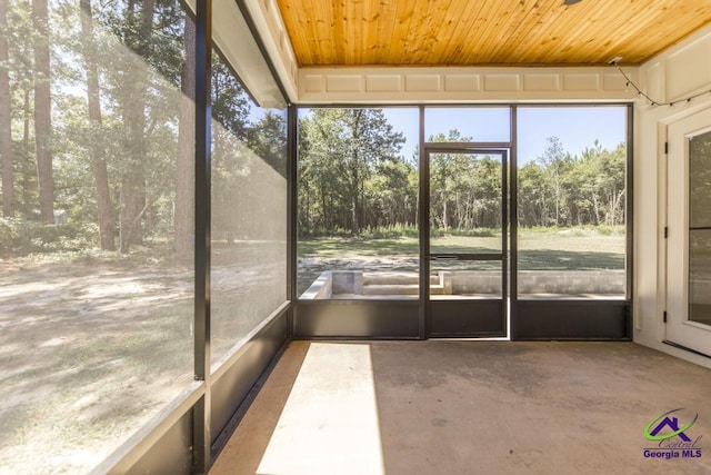 unfurnished sunroom with a healthy amount of sunlight and wooden ceiling