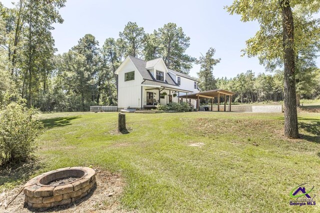 view of front facade featuring an outdoor fire pit and a front yard